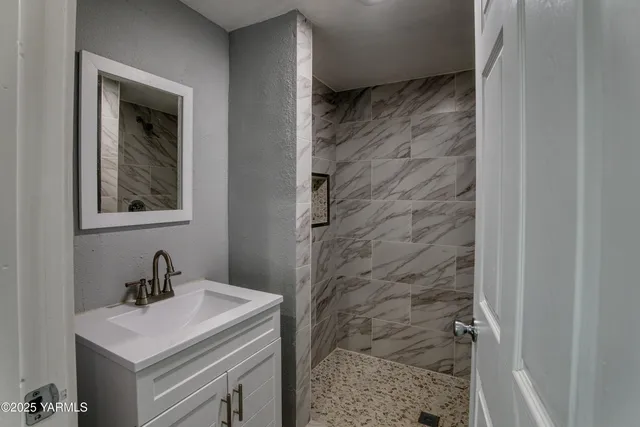 a bathroom with a sink a mirror and shower