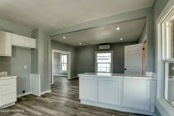a view of a hallway to kitchen and wooden floor