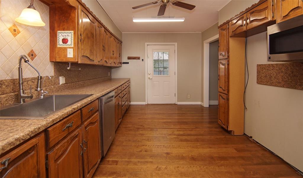 730 Indiana Street Graham, TX 76450 - Photo 13 of 25 a view of a kitchen with stainless steel appliances granite countertop a sink and cabinets