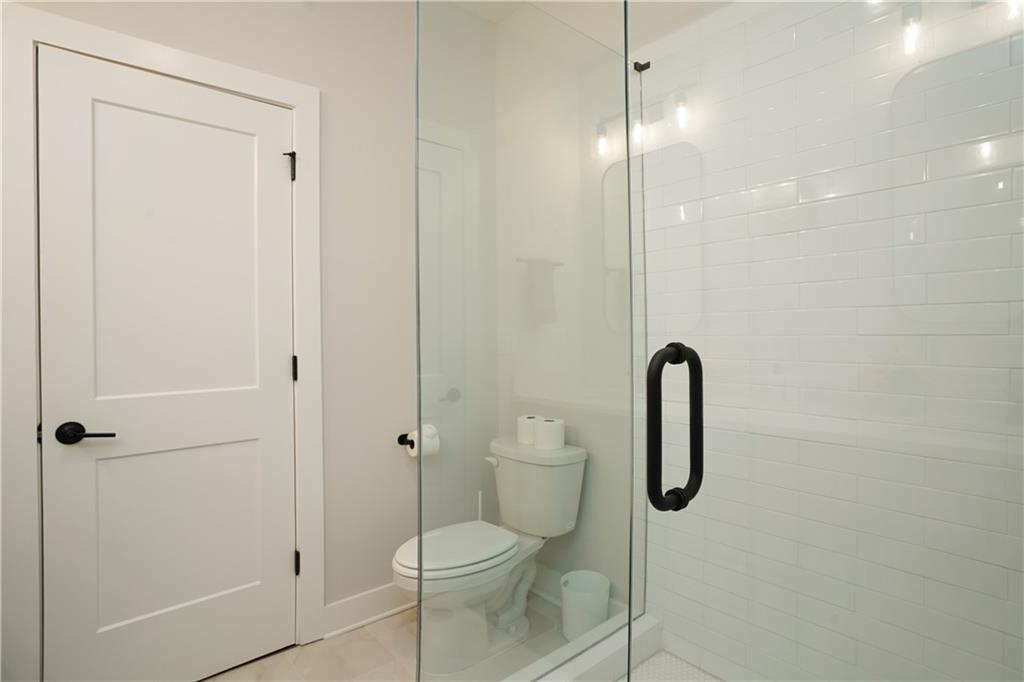154 Chestnut Circle, Unit 80 Atlanta, GA 30342 - Photo 12 of 31 a bathroom with a shower a toilet and sink