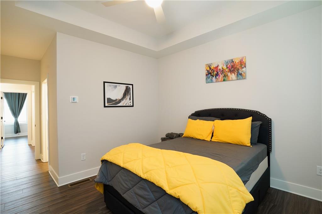 154 Chestnut Circle, Unit 80 Atlanta, GA 30342 - Photo 13 of 31 a bedroom with a bed and wooden floor