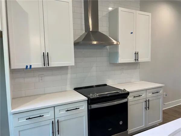 a kitchen with a stove and a wooden cabinets