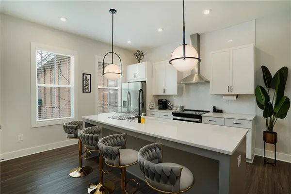 a kitchen with stainless steel appliances granite countertop a stove a sink dishwasher a dining table and chairs with wooden floor