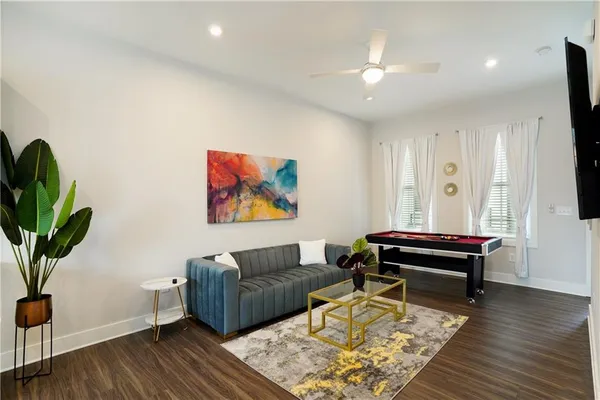 a living room with furniture a wooden floor and a potted plant