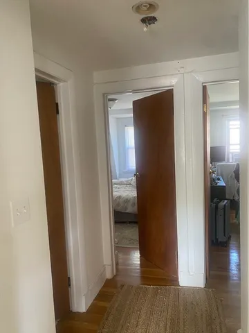 a view of a hallway with wooden floor and closet