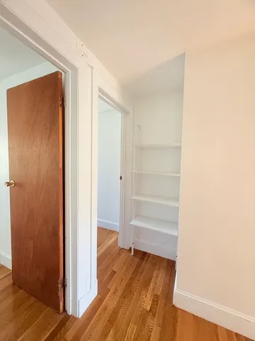 a view of walk in closet with wooden floor