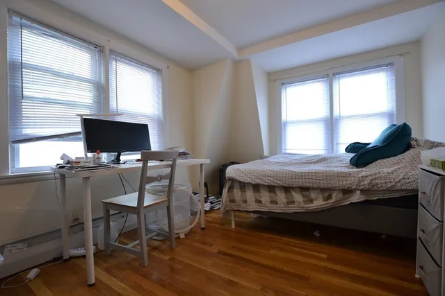 a bedroom with a bed window and a flat screen tv