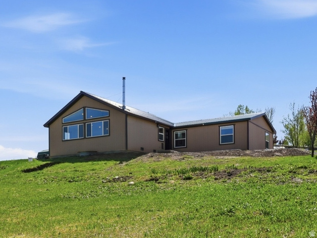 8066 North Valley View Heights Preston, ID 83263 - Photo 1 of 34 Expansive green grounds surrounding a single-story residence with a brown exterior and a dark roof