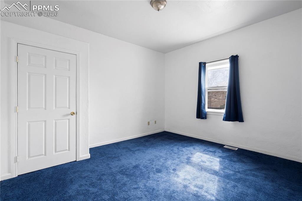 2232 East Routt Avenue Pueblo, CO 81004 - Photo 12 of 21 an empty room with wooden floor and windows