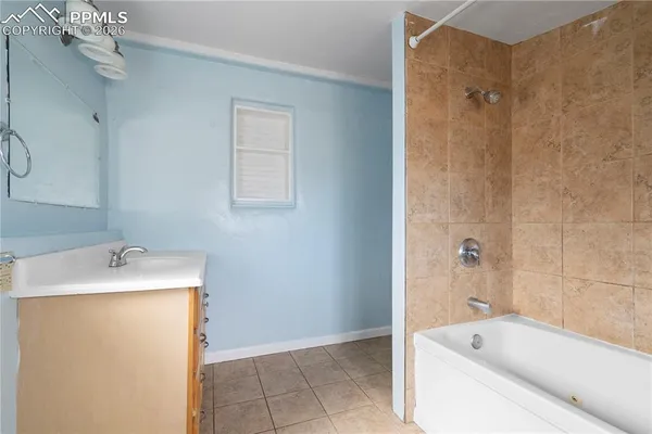 a bathroom with a tub sink and mirror