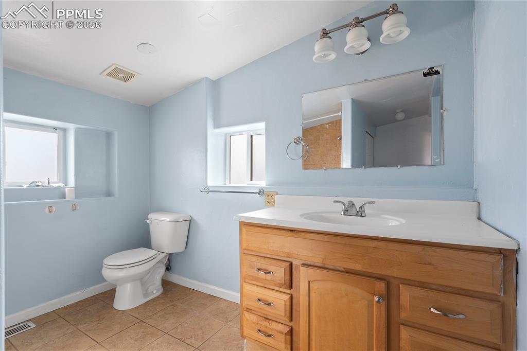 2232 East Routt Avenue Pueblo, CO 81004 - Photo 15 of 21 a bathroom with a toilet sink and mirror
