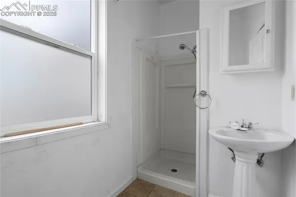 a bathroom with a shower sink and mirror