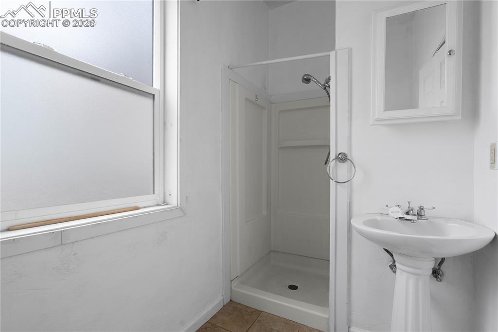 2232 East Routt Avenue Pueblo, CO 81004 - Photo 16 of 21 a bathroom with a shower sink and mirror
