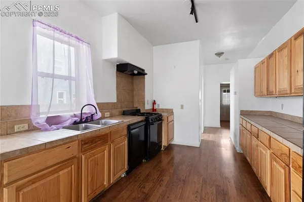 a kitchen with stainless steel appliances a sink dishwasher stove and wooden cabinets