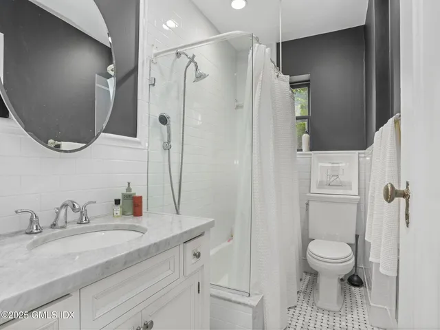 a bathroom with a granite countertop sink toilet a shower and a mirror