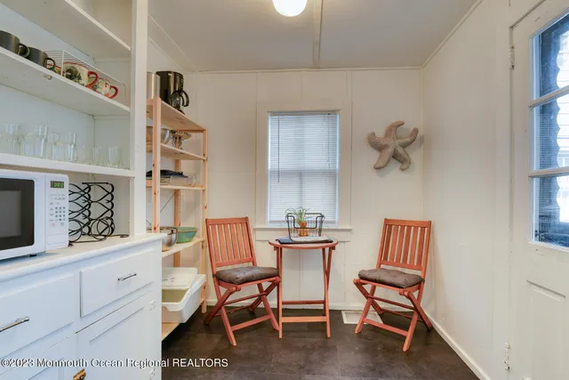 a dining room with furniture and a painting on the wall