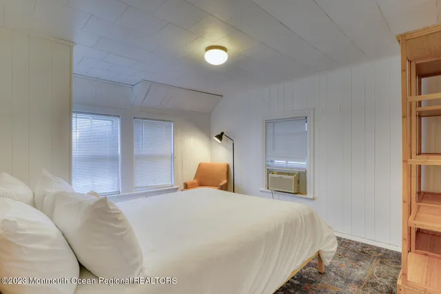 a bedroom with a bed and a lamp on dresser