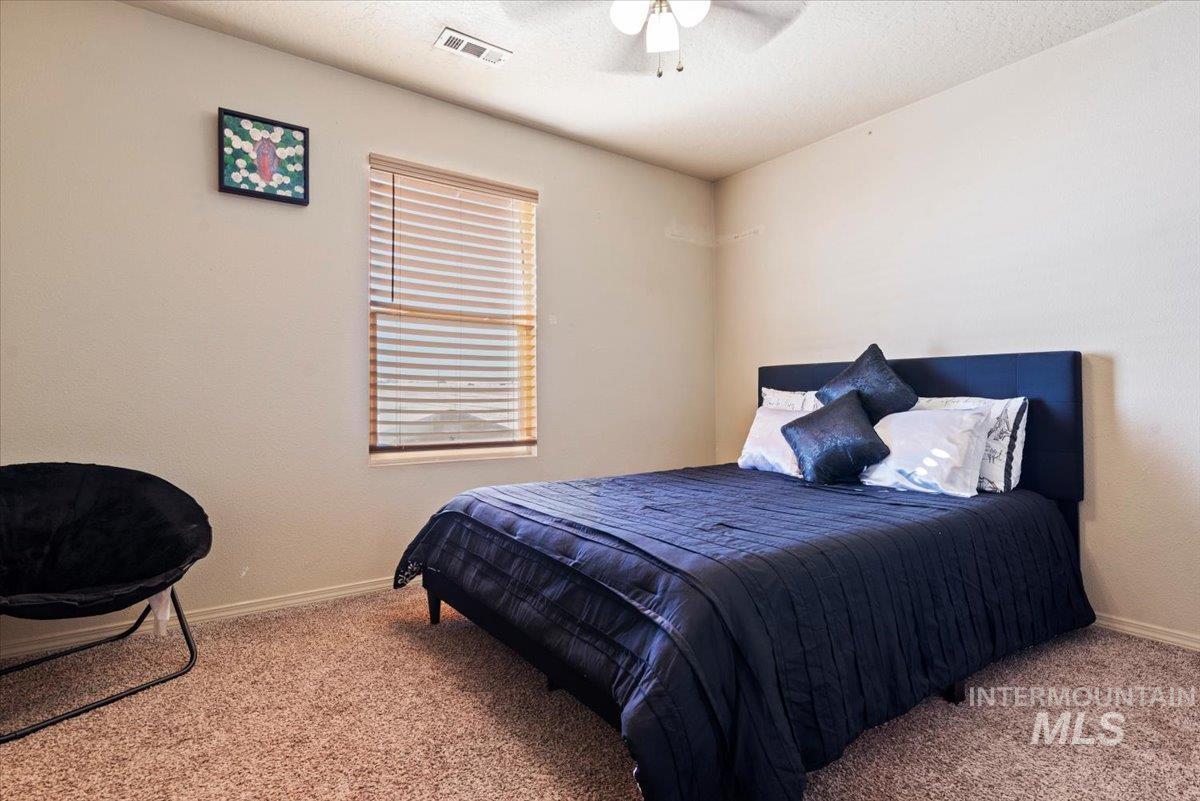 14057 Santa Cruz Street Caldwell, ID 83607 - Photo 15 of 26 Bedroom with light carpet, ceiling fan, and a textured ceiling