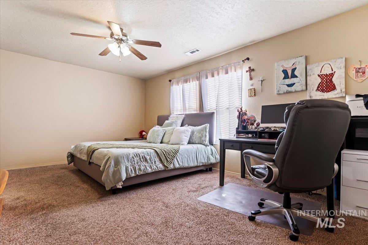 14057 Santa Cruz Street Caldwell, ID 83607 - Photo 16 of 26 Bedroom with carpet floors, a textured ceiling, a ceiling fan, and an office area