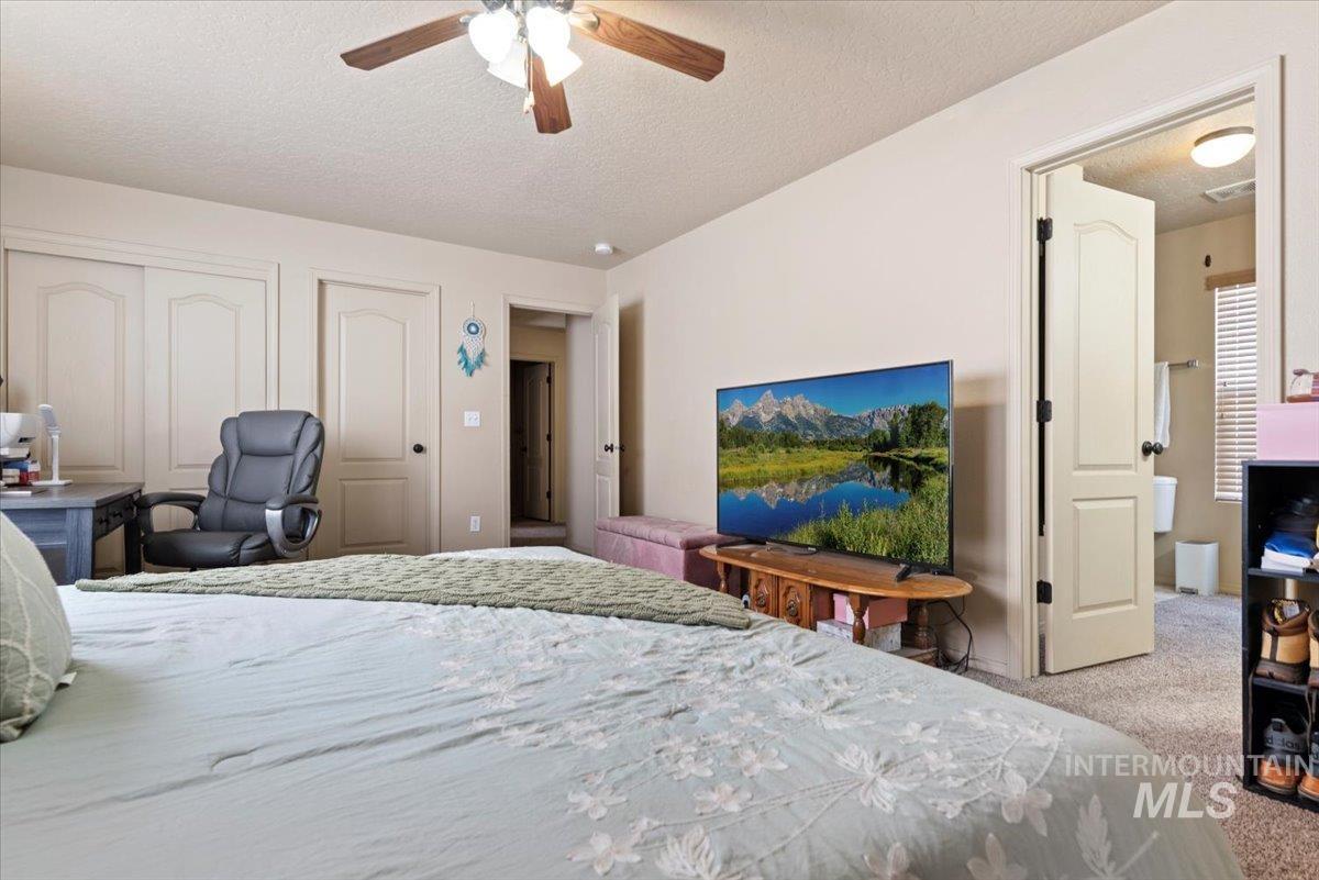 14057 Santa Cruz Street Caldwell, ID 83607 - Photo 17 of 26 Bedroom featuring carpet, a closet, a textured ceiling, an office area, and a ceiling fan