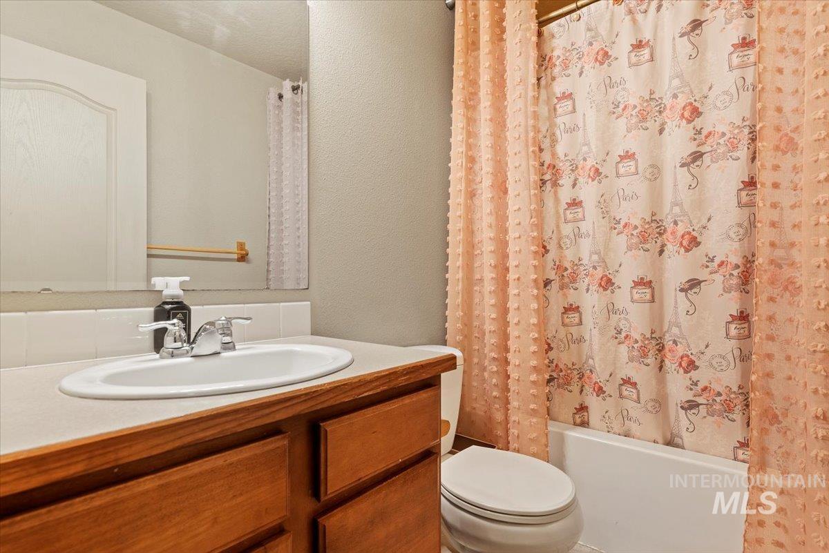 14057 Santa Cruz Street Caldwell, ID 83607 - Photo 18 of 26 Bathroom featuring a textured wall, vanity, and shower / bath combo with shower curtain