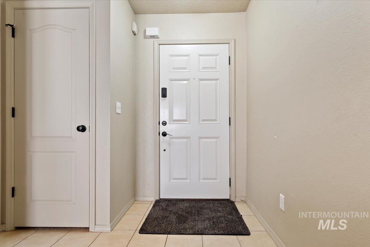 14057 Santa Cruz Street Caldwell, ID 83607 - Photo 4 of 26 Doorway to outside featuring tile patterned flooring and baseboards