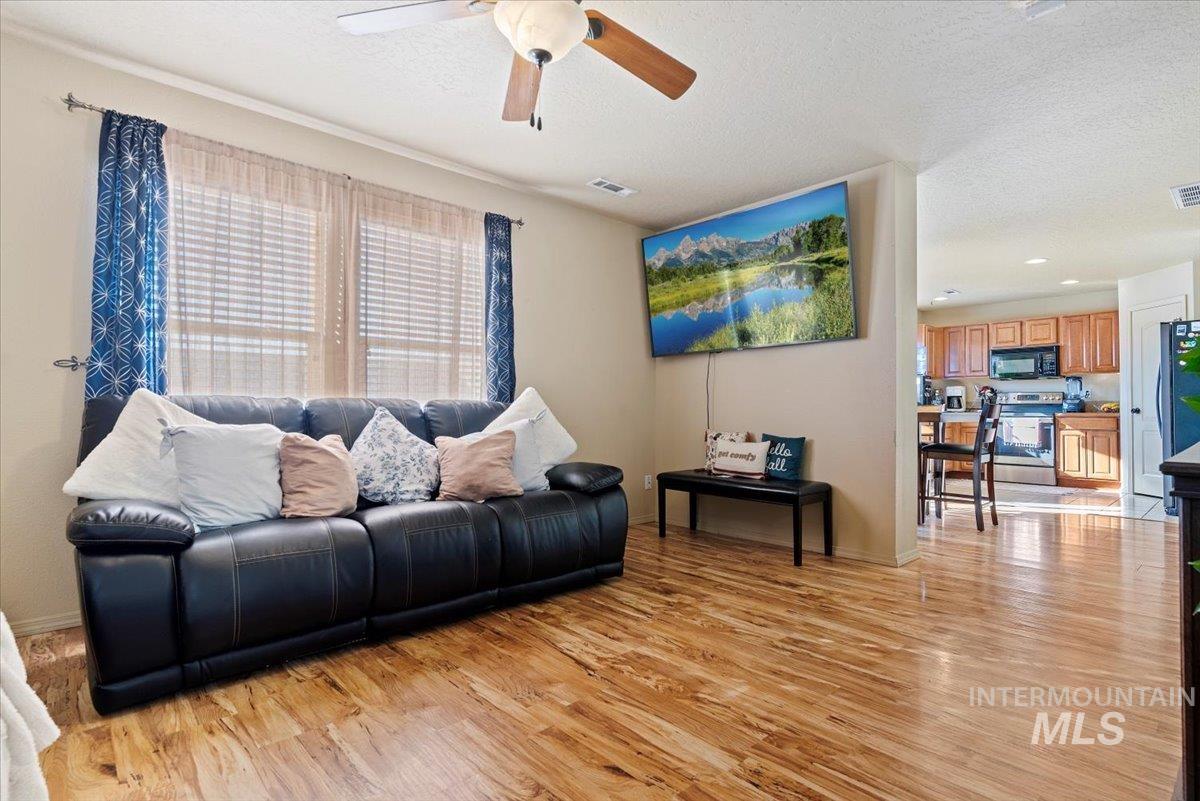 14057 Santa Cruz Street Caldwell, ID 83607 - Photo 5 of 26 Living room featuring light wood-style flooring, a textured ceiling, a ceiling fan, and recessed lighting