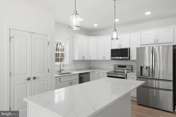 a kitchen with stainless steel appliances a refrigerator sink and microwave