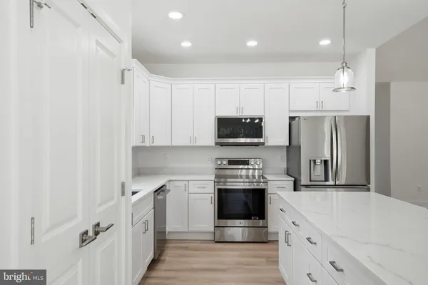 a kitchen with stainless steel appliances a refrigerator sink and stove