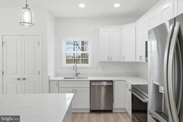 a kitchen with stainless steel appliances a refrigerator sink and cabinets