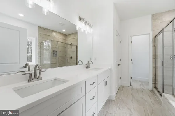 a bathroom with double vanity sinks and a mirror