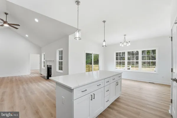 a large kitchen with kitchen island a large window and wooden floor