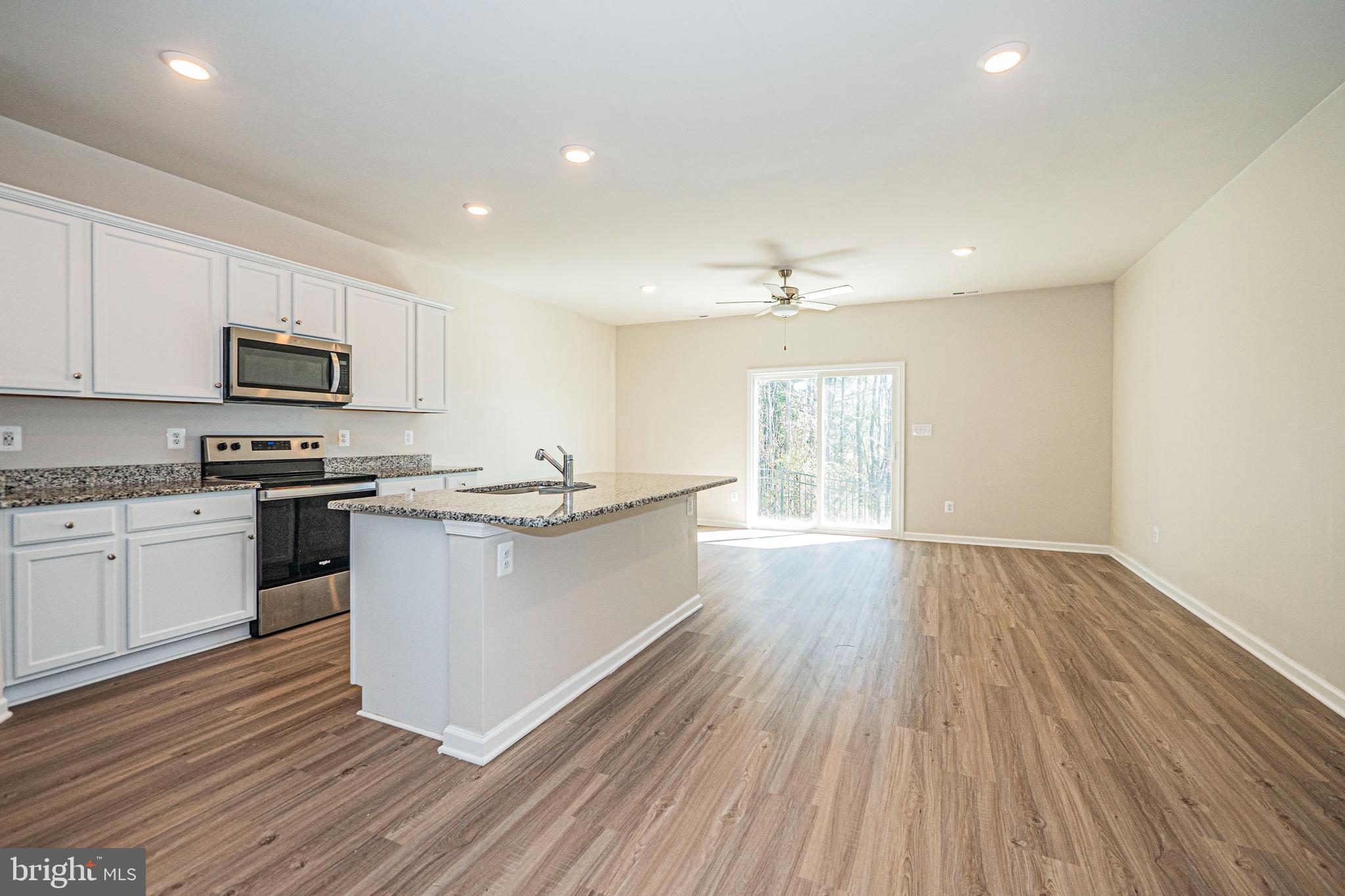 120 Paddington Street Falling Waters, WV 25419 - Photo 2 of 34 a kitchen with granite countertop wooden floors a stove top oven a sink and dishwasher with wooden floor