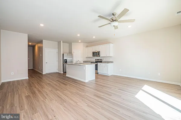 a view of kitchen with granite countertop cabinets and refrigerator