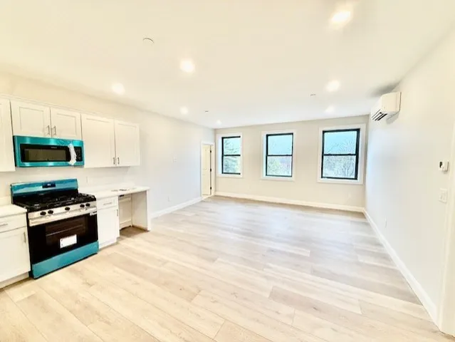 a kitchen with granite countertop a stove top oven and cabinets