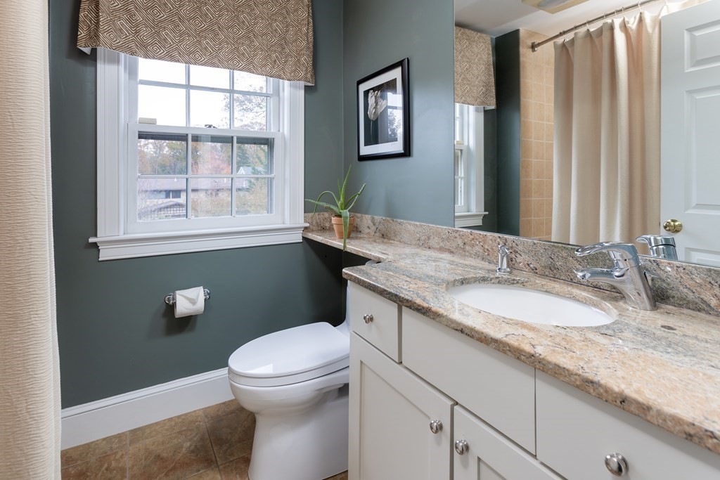 47 Arlington Road Brookline, MA 02467 - Photo 23 of 29 a bathroom with a granite countertop toilet a sink and a mirror