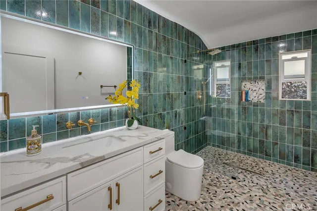 a bathroom with a sink a toilet and shower