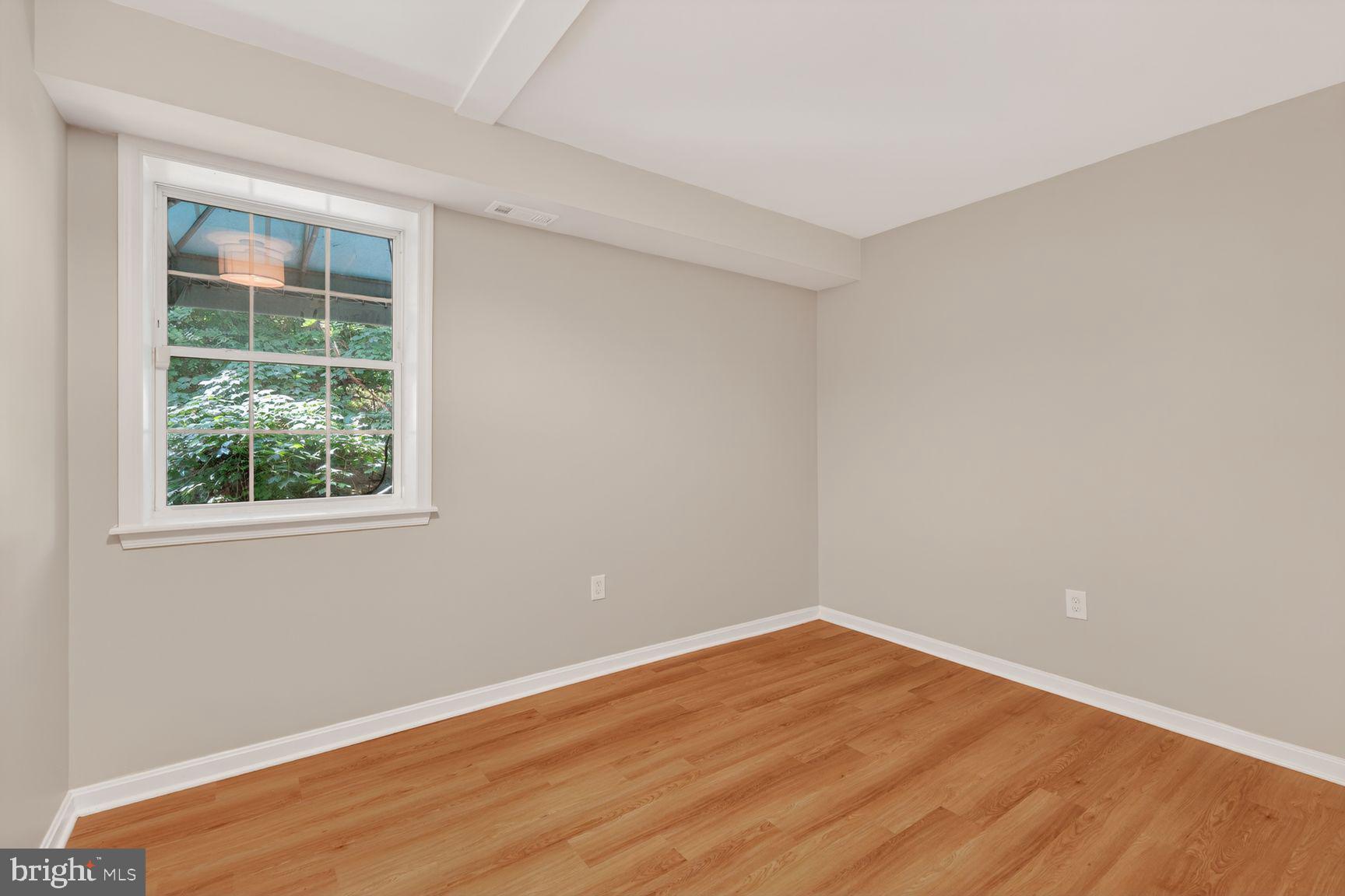 1008 Rittenhouse Street Northwest, Unit 15 Washington, DC 20011 - Photo 37 of 39 a view of an empty room with wooden floor and a window