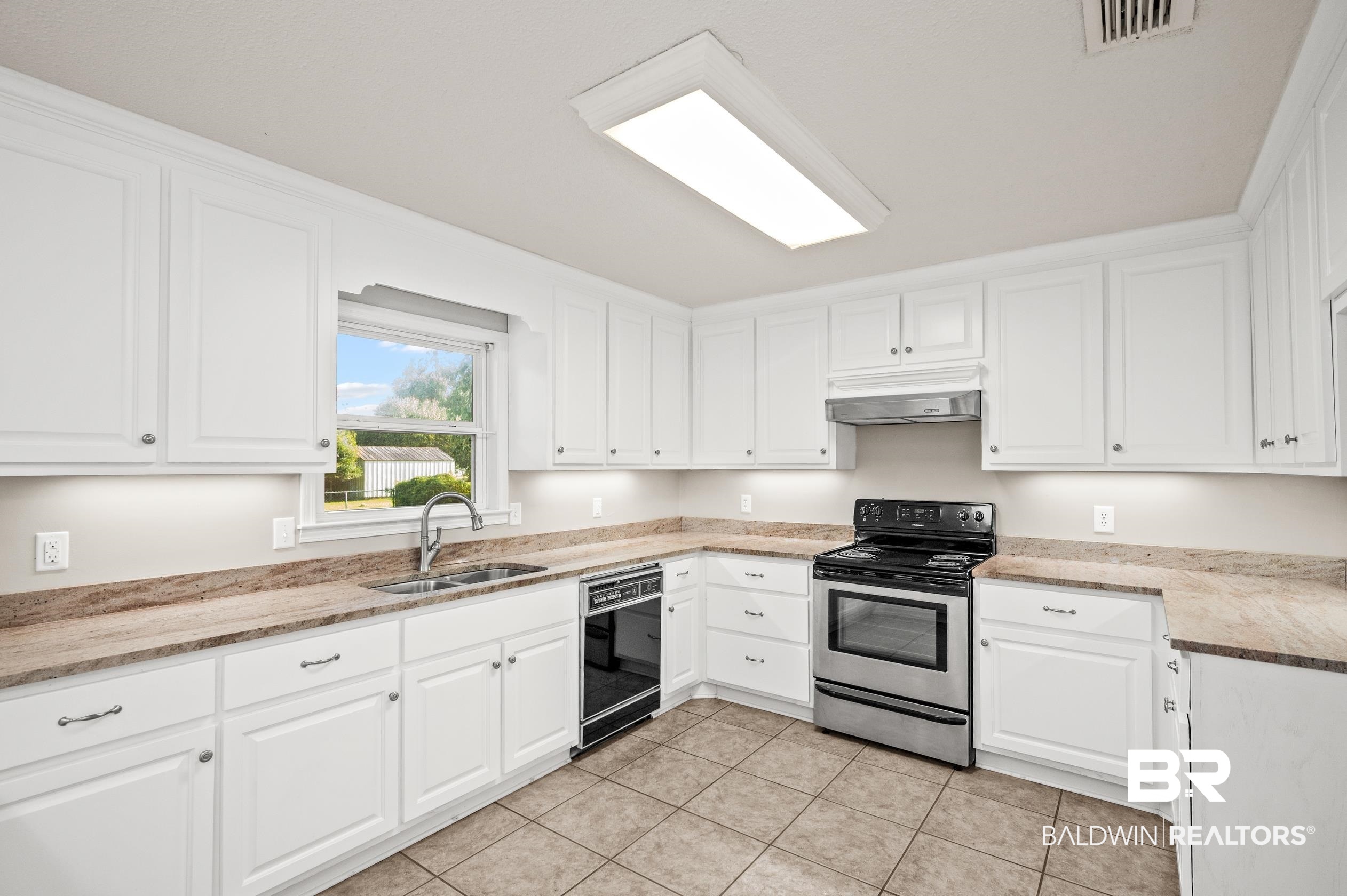 303 West Palm Avenue Foley, AL 36535 - Photo 5 of 32 Kitchen featuring white cabinetry, light tile patterned floors, stainless steel electric range, and sink