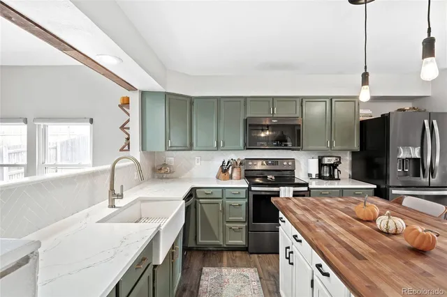 a kitchen with stainless steel appliances granite countertop a sink a stove and a refrigerator