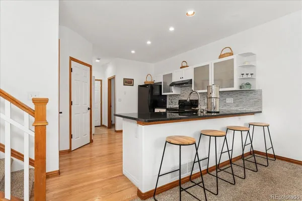 a kitchen with stainless steel appliances granite countertop a refrigerator and a stove top oven