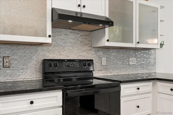 a kitchen with granite countertop cabinets stove and oven
