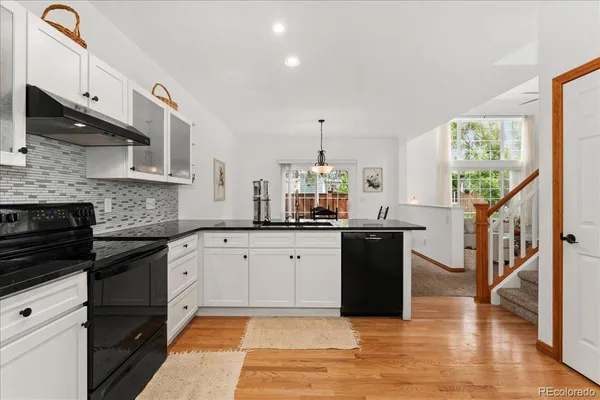 a kitchen with granite countertop a stove a sink and a refrigerator