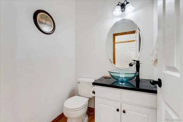 a bathroom with a toilet mirror and vanity