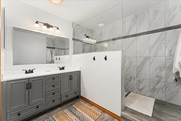 a bathroom with a double vanity sink a toilet and mirror