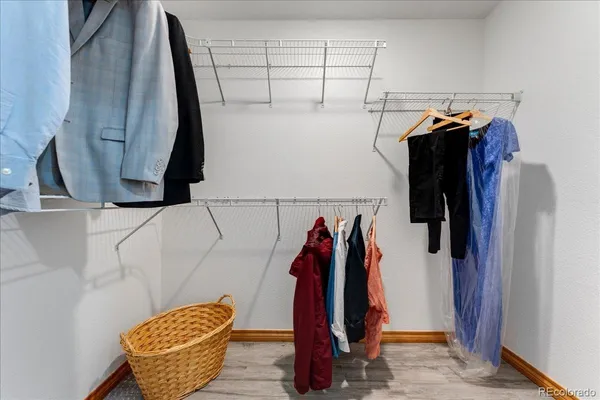 a view of walk in closet with clothes and shoes
