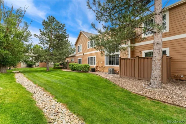 a view of a house with backyard and a tree