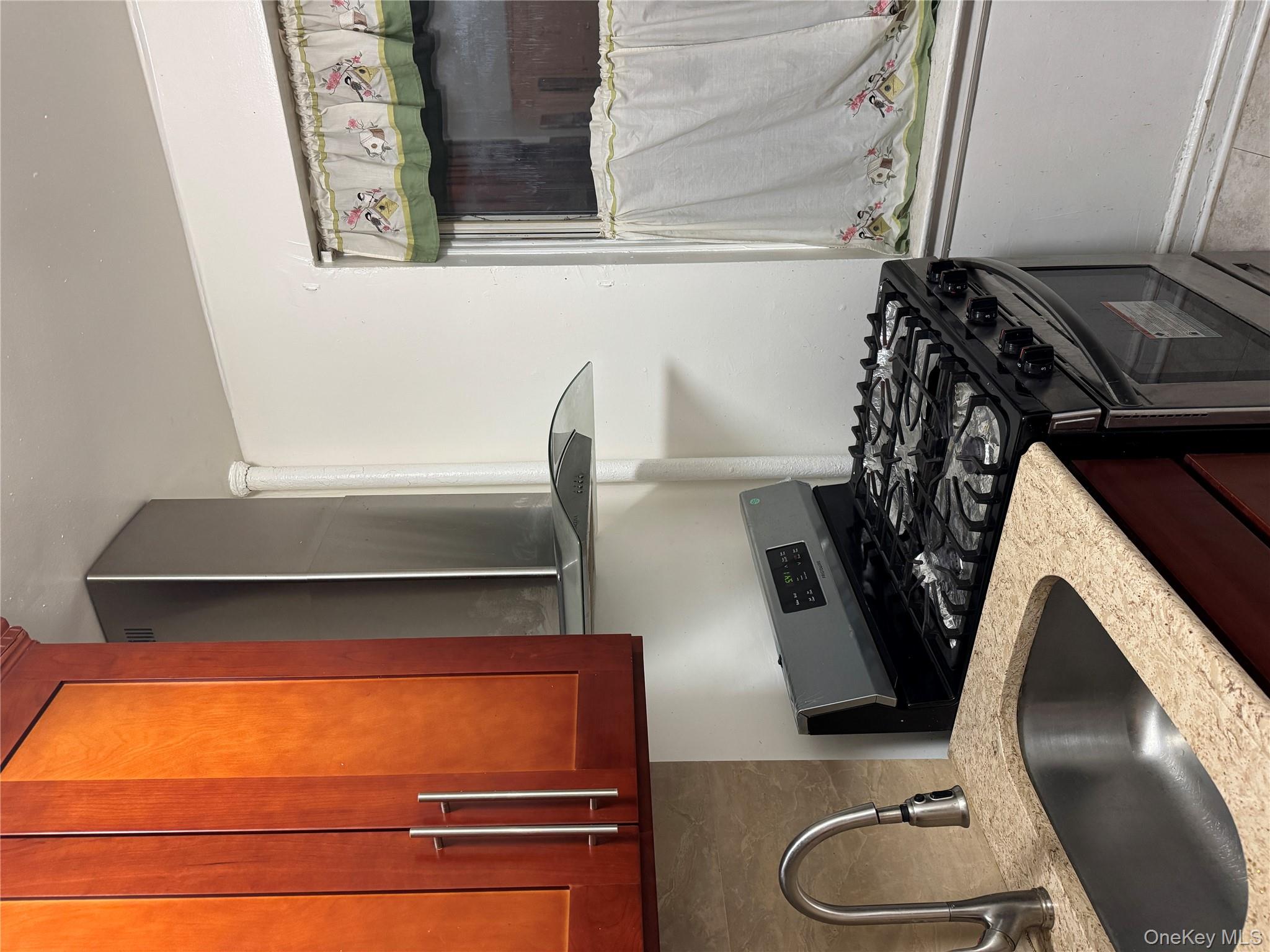 141-17 78th Road, Unit 1O Queens, NY 11367 - Photo 4 of 17 Kitchen featuring ventilation hood, range, light stone counters, light tile patterned floors, and backsplash