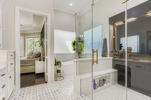 a bathroom with a tub sink shower and mirror