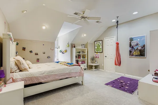 a bedroom with a bed chandelier and a window